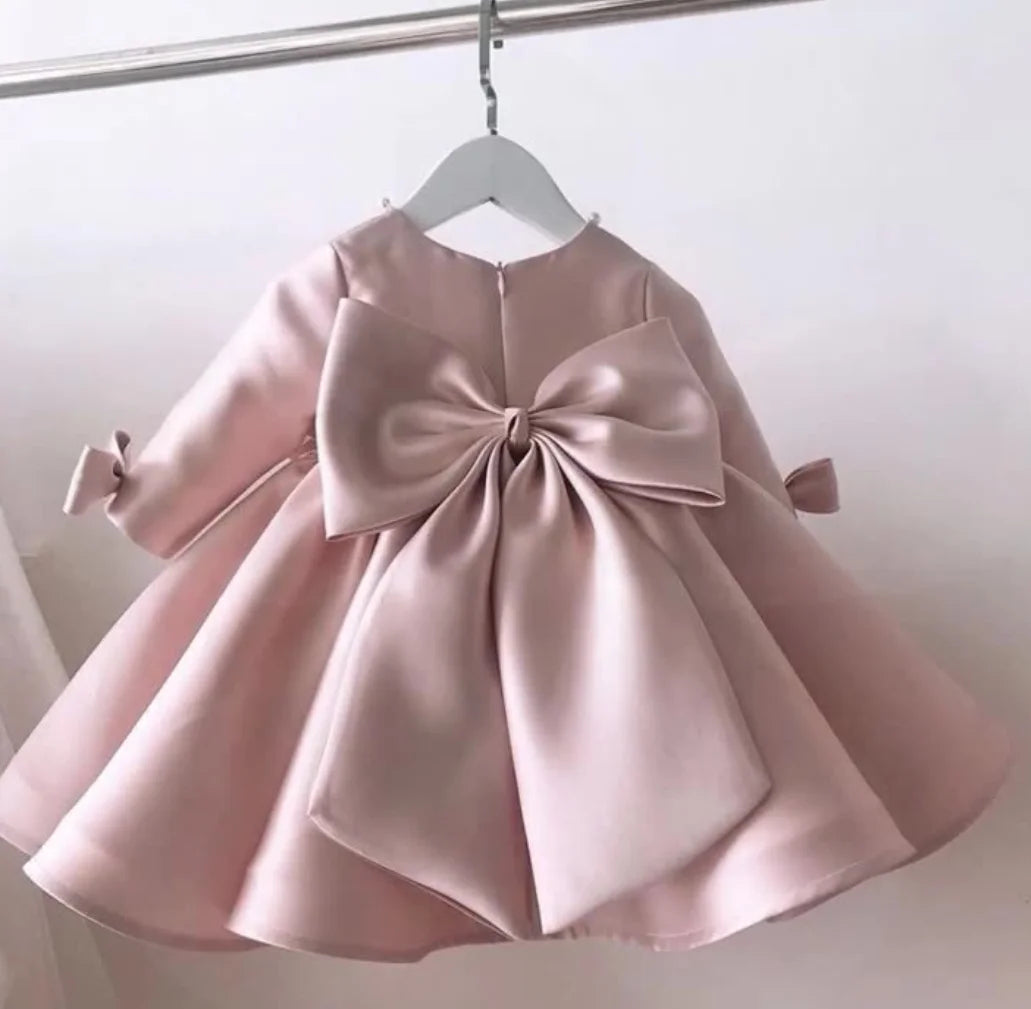baby pink special occasion dress with large bow back detail and long sleeves for infants