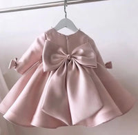 baby pink special occasion dress with large bow back detail and long sleeves for infants