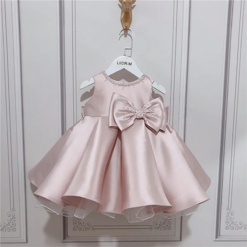 baby pink special occasion dress with large bow and sleeveless design for infants