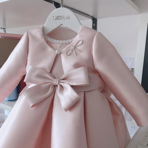 girls pink special occasion dress with pearl neckline and large bow for infants