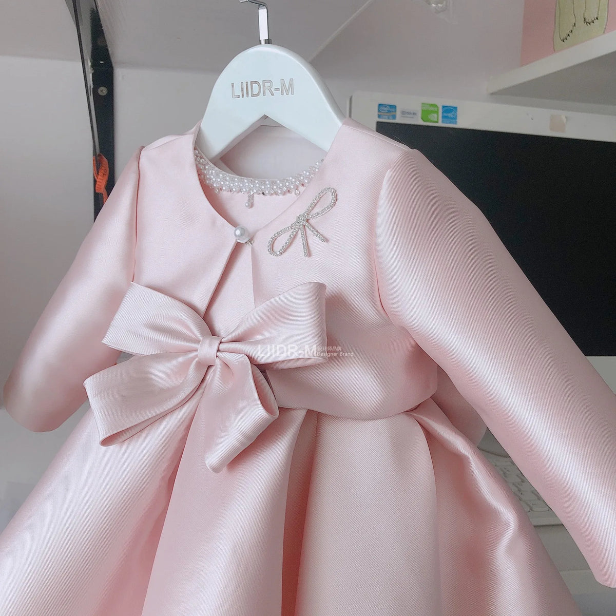 Baby pink special occasion dress for girls with long sleeves and large bow detail