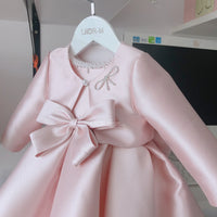 Baby pink special occasion dress for girls with long sleeves and large bow detail