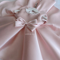 baby pink special occasion dress with neckline and large bow for infants