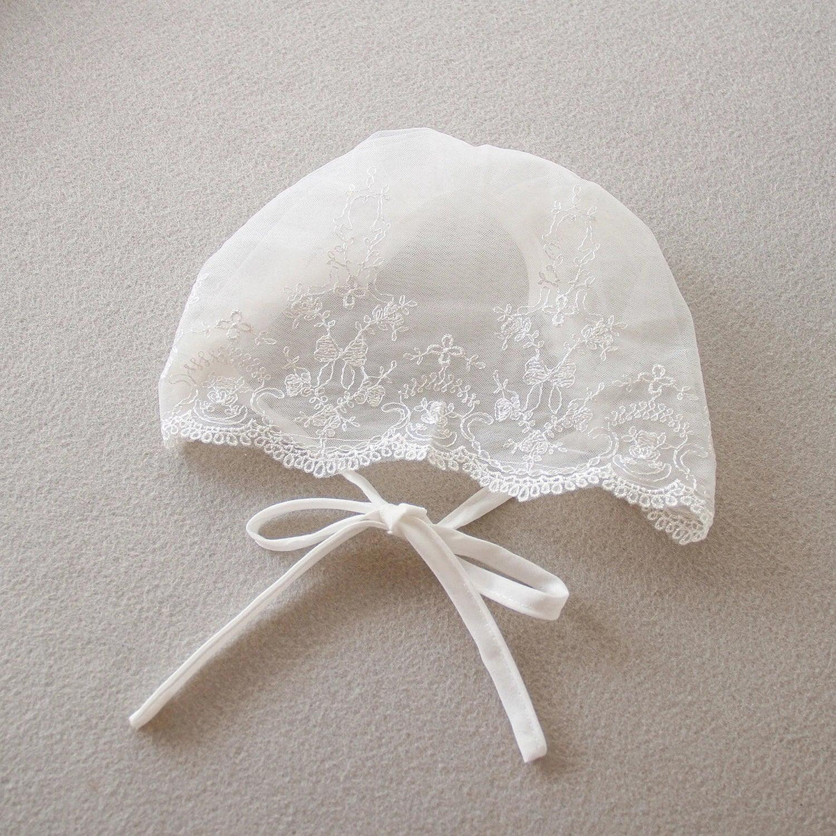 white delicate lace baby bonnet with floral embroidery and tie strings for special occasion dress