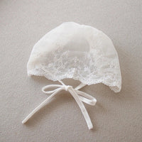 white delicate lace baby bonnet with floral embroidery and tie strings for special occasion dress