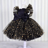 girls black and gold special occasion dress with lace star pattern and large bow for toddlers