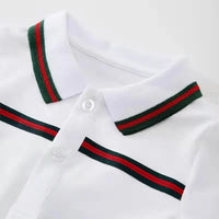 white sporty baby summer romper with green and red striped collar and chest detail for infants