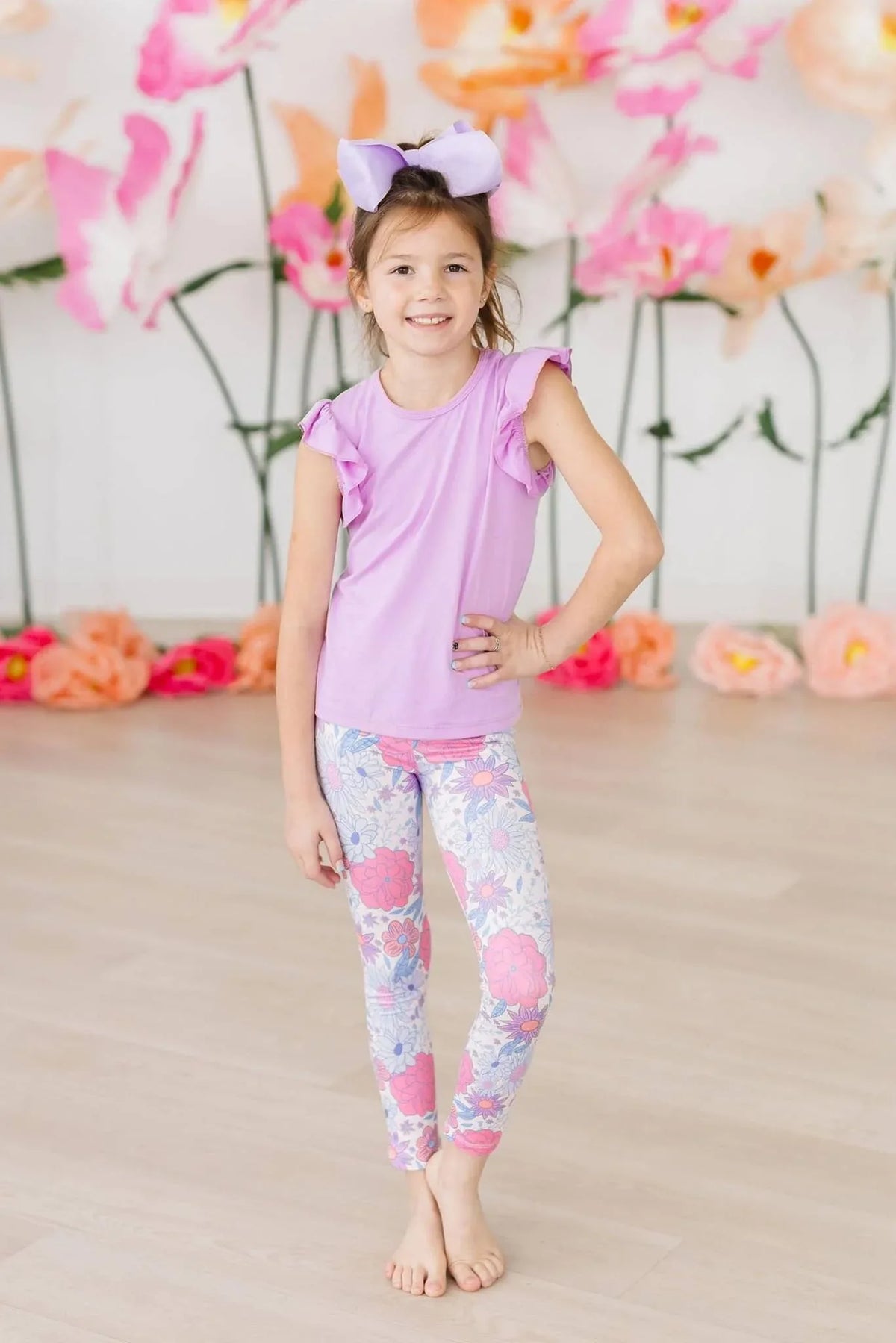 Young girl wearing Mila & Rose spring leggings for girls in floral pattern, standing with hand on hip