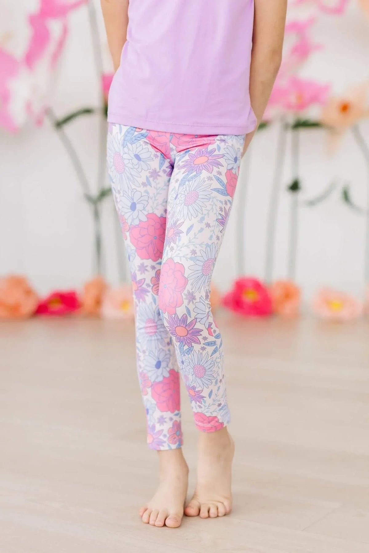 girl wearing floral pink and white spring leggings for girls standing barefoot indoors