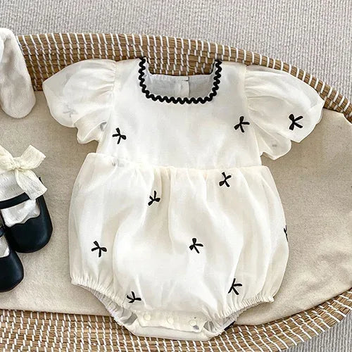 baby white summer rompers with black bow details and puff sleeves for infants