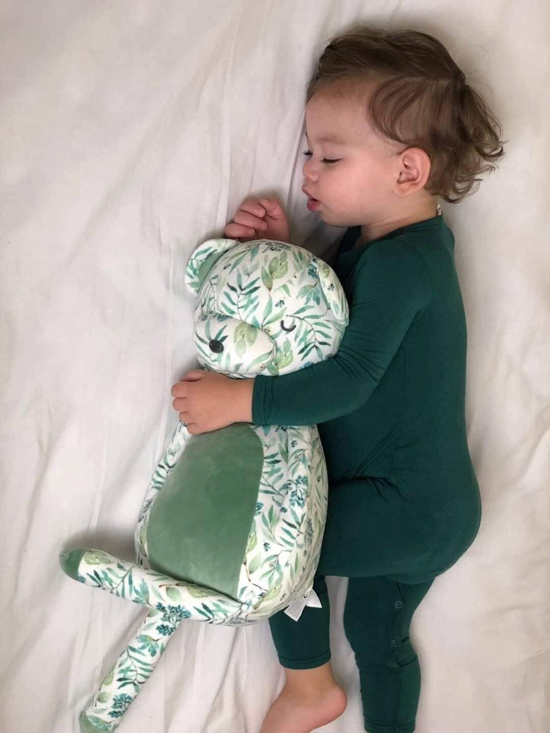 Green and white patterned plush bear held by toddler wearing green pajamas super soft baby comfort toy