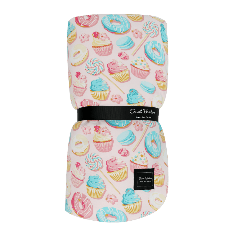 Folded blanket with colorful dessert pattern on a green background