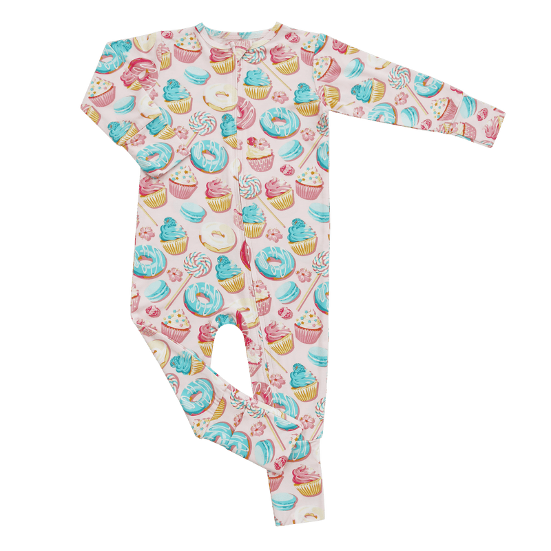Children's onesie with colorful donut and cupcake pattern on a green background