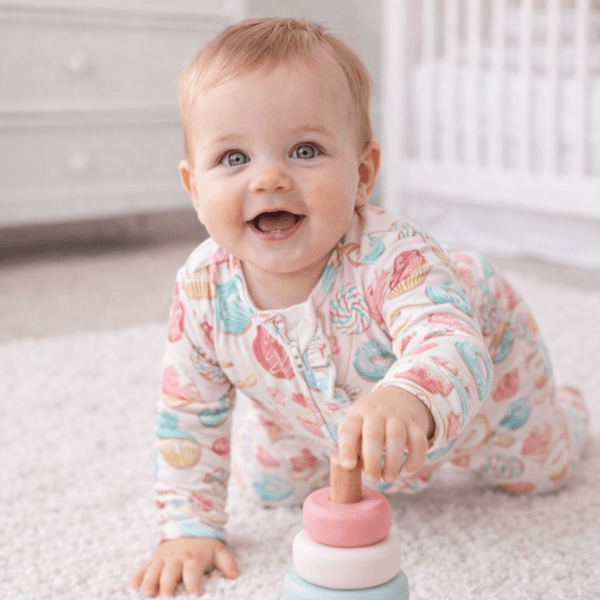 Baby in Sweet Tooth Ruffle Footie with ruffle bottom, silky-smooth hypoallergenic fabric, and a 2-way zipper.