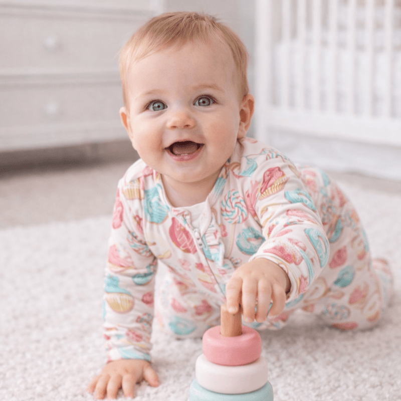 Baby in Sweet Tooth Ruffle Footie with ruffle bottom, silky-smooth hypoallergenic fabric, and a 2-way zipper.