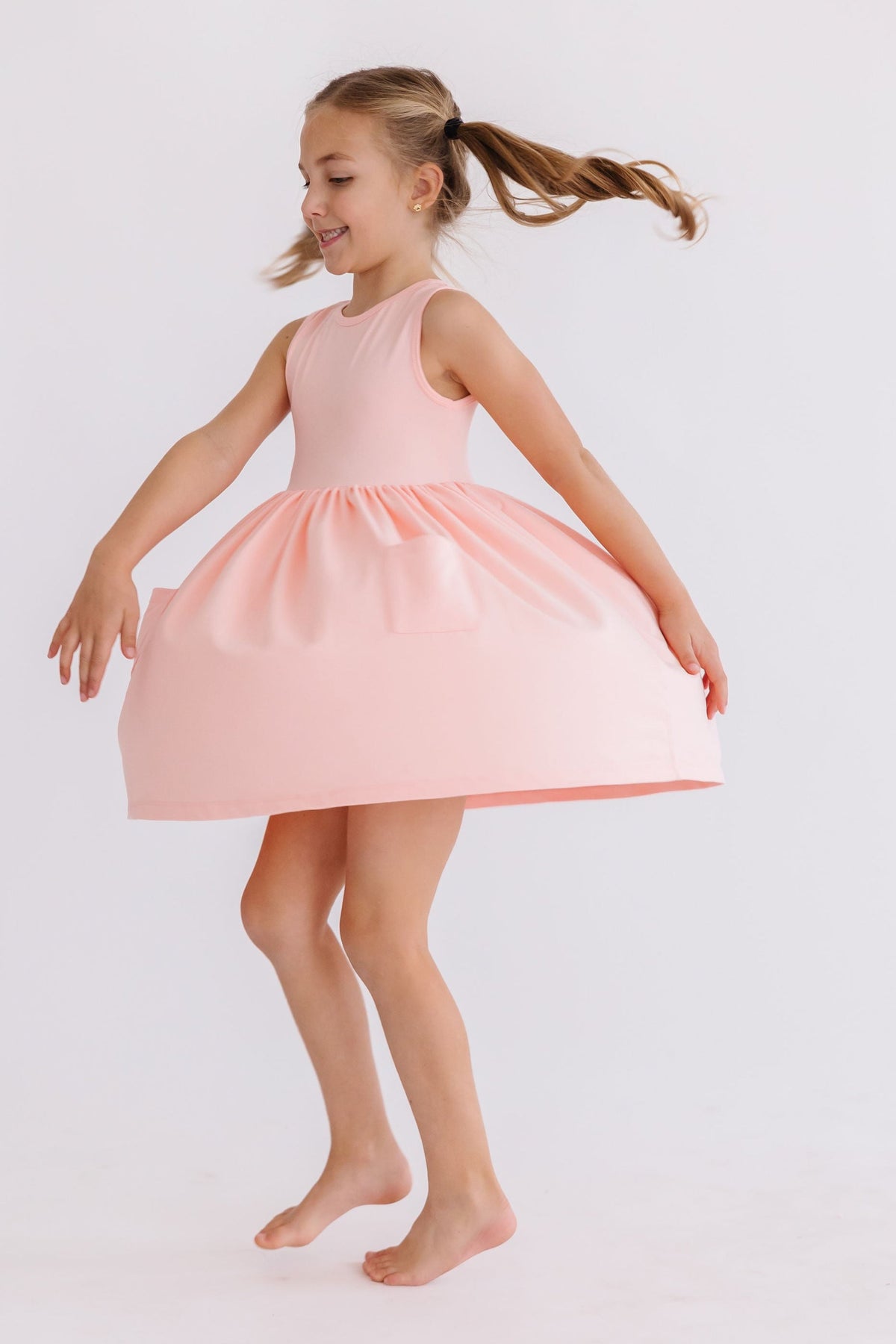 Girls light pink twirl pocket tank dress by Mila Rose with sleeveless design and full skirt