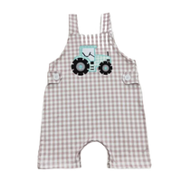 Beige and white checkered toddler romper with blue tractor applique and button straps