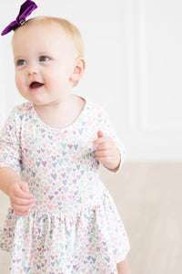 Toddler girl wearing Mila & Rose toddler twirl dress with 3/4 sleeves and pastel heart print