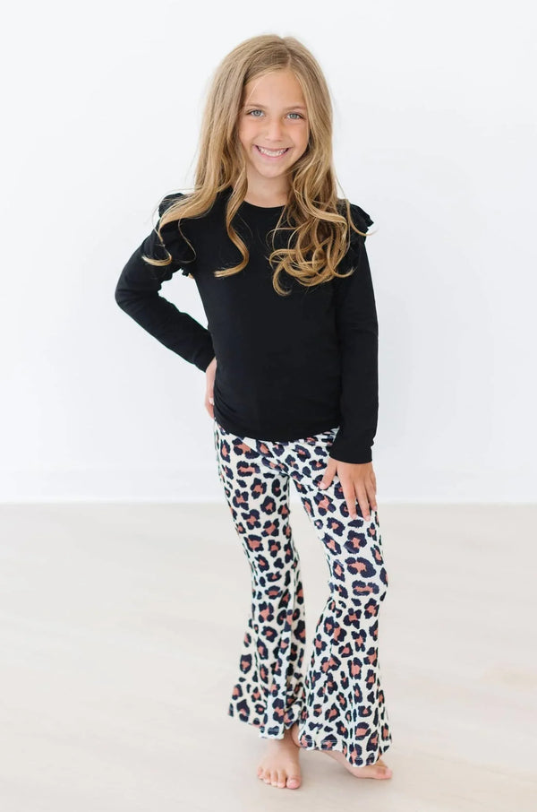 Young girl wearing white leopard print toddler velvet bell bottom pants smiling with hand on hip