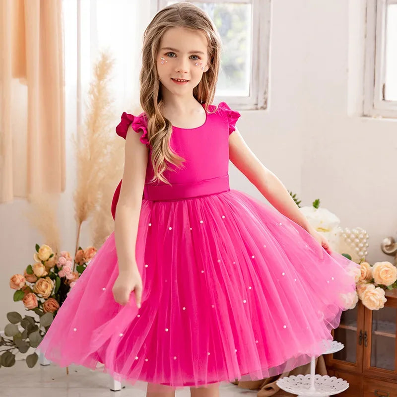 Girls bright pink tulle party dress with pearl details and ruffle sleeves for ages 4 to 6