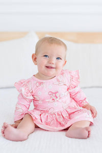 baby girl wearing pink twirl bodysuit with 3/4 flutter sleeves sitting and smiling