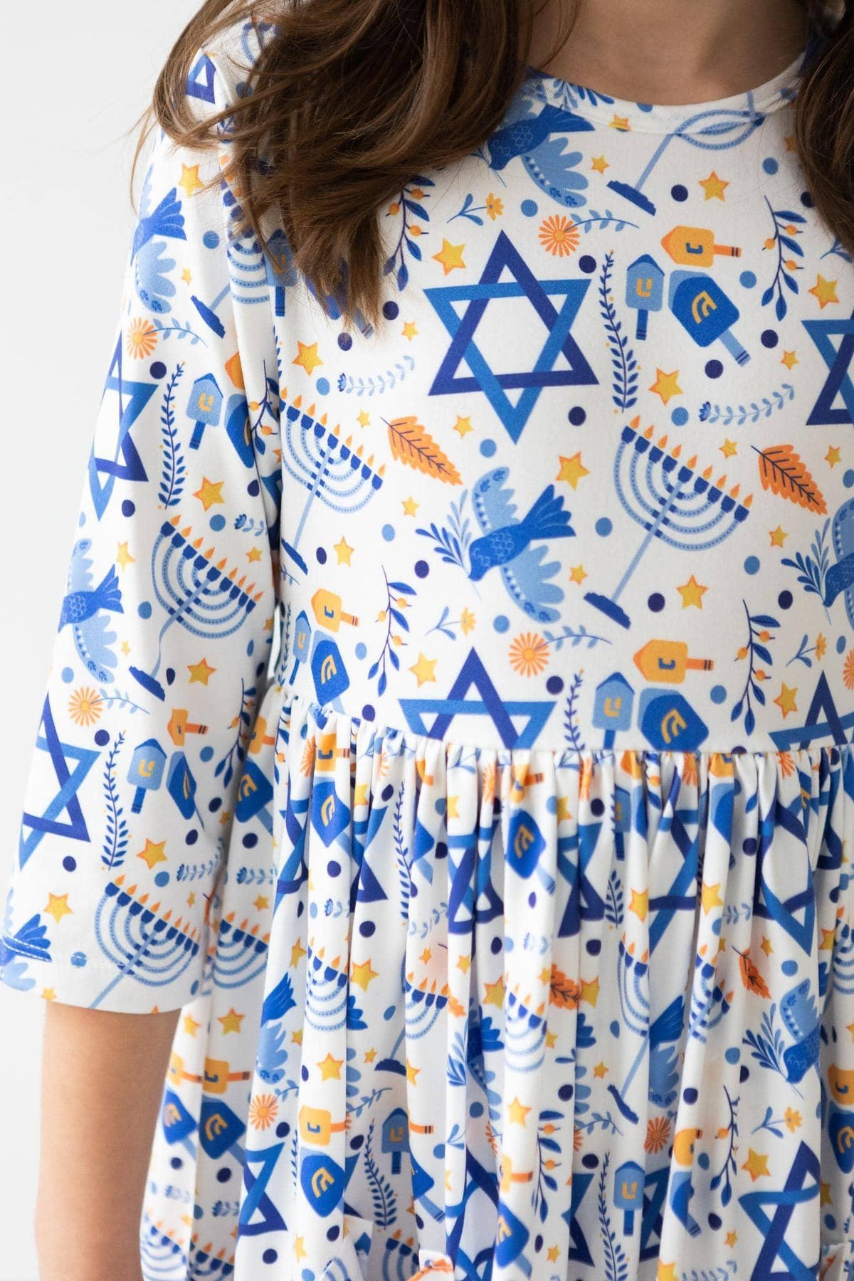 Girls white twirl dress with sleeves featuring blue menorahs and Star of David pattern