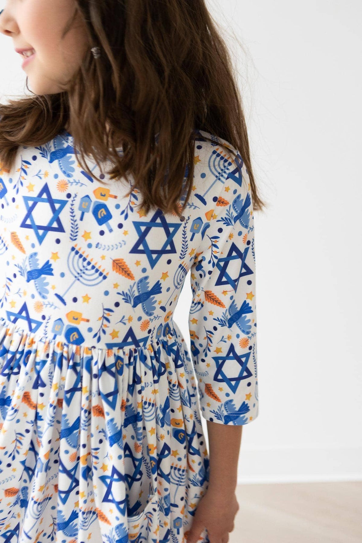 Girls white and blue twirl dress with sleeves featuring Hanukkah themed Star of David print