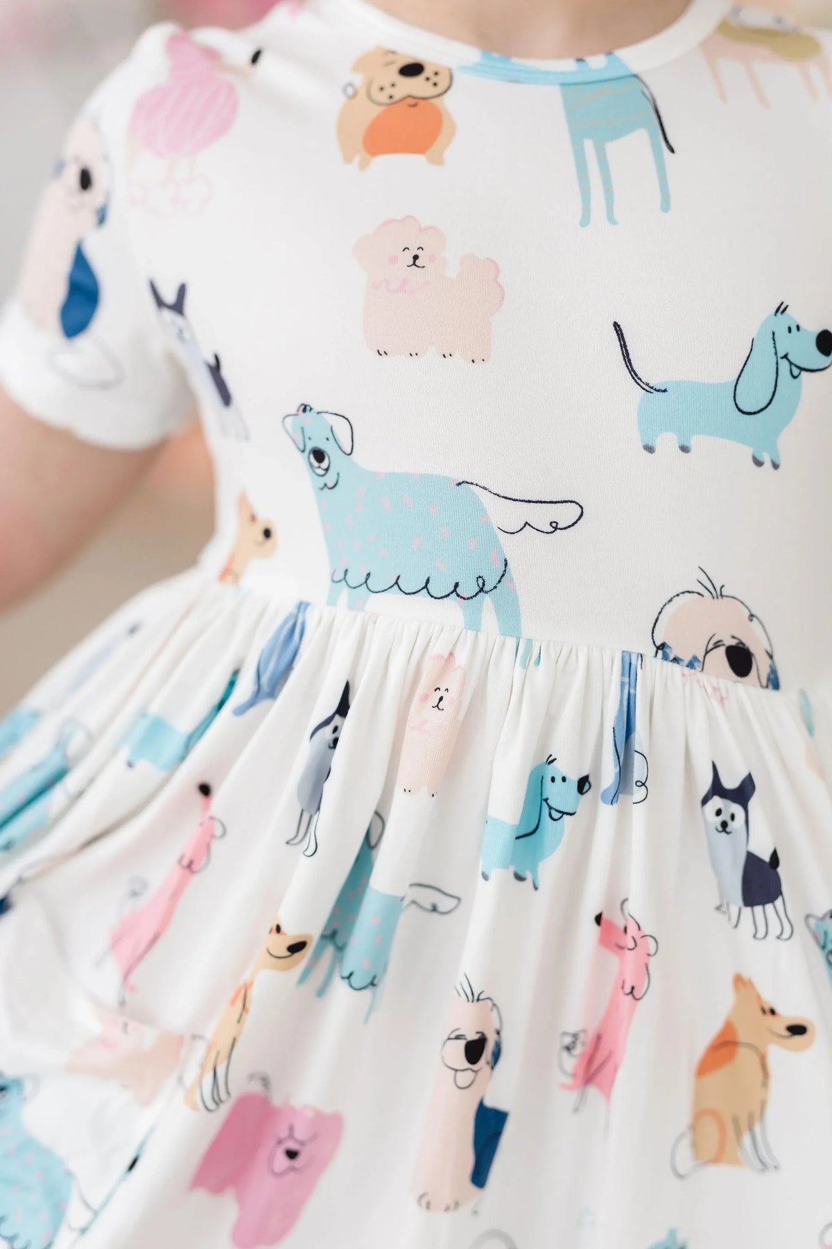 Toddler girl wearing white twirl dress for girls with colorful dog prints, spinning in dress