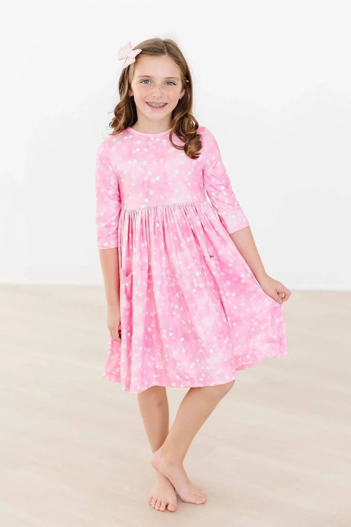 Girls pink twirl dress with white polka dots 3/4 sleeves and pockets by Mila & Rose