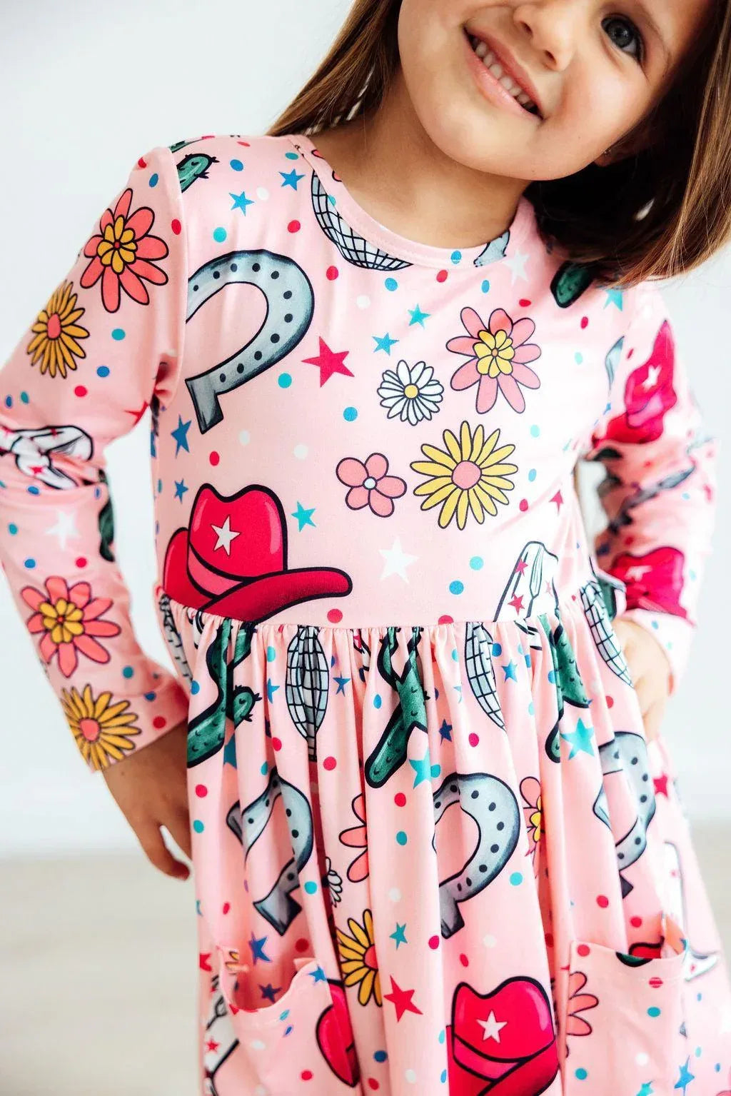 Girls pink twirl dress with cowboy hat and flower print long sleeves and pockets