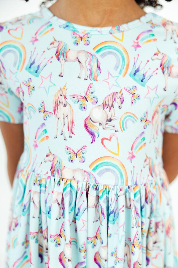 toddler girl wearing Mila & Rose unicorn dress for toddlers with rainbows and butterflies standing still