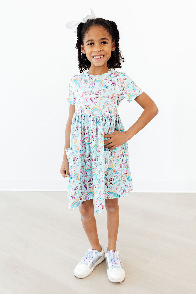 Toddler girl wearing Mila & Rose unicorn dress for toddlers twirl pocket dress smiling and posing