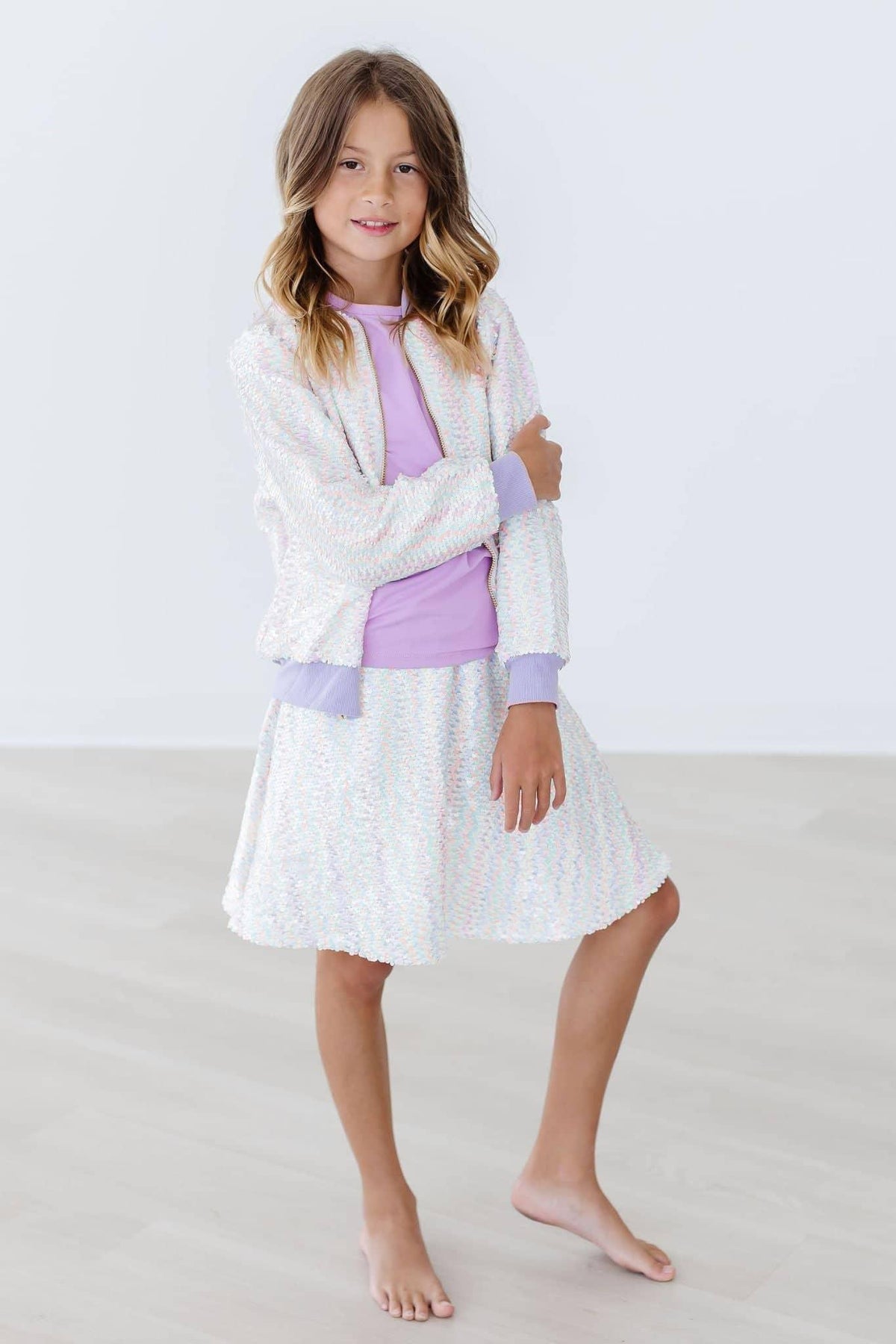 Girl wearing white unicorn sequin jacket for girls by Mila & Rose standing barefoot with arms crossed
