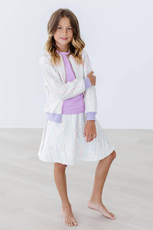 Girl wearing white unicorn sequin jacket for girls by Mila & Rose standing barefoot with arms crossed