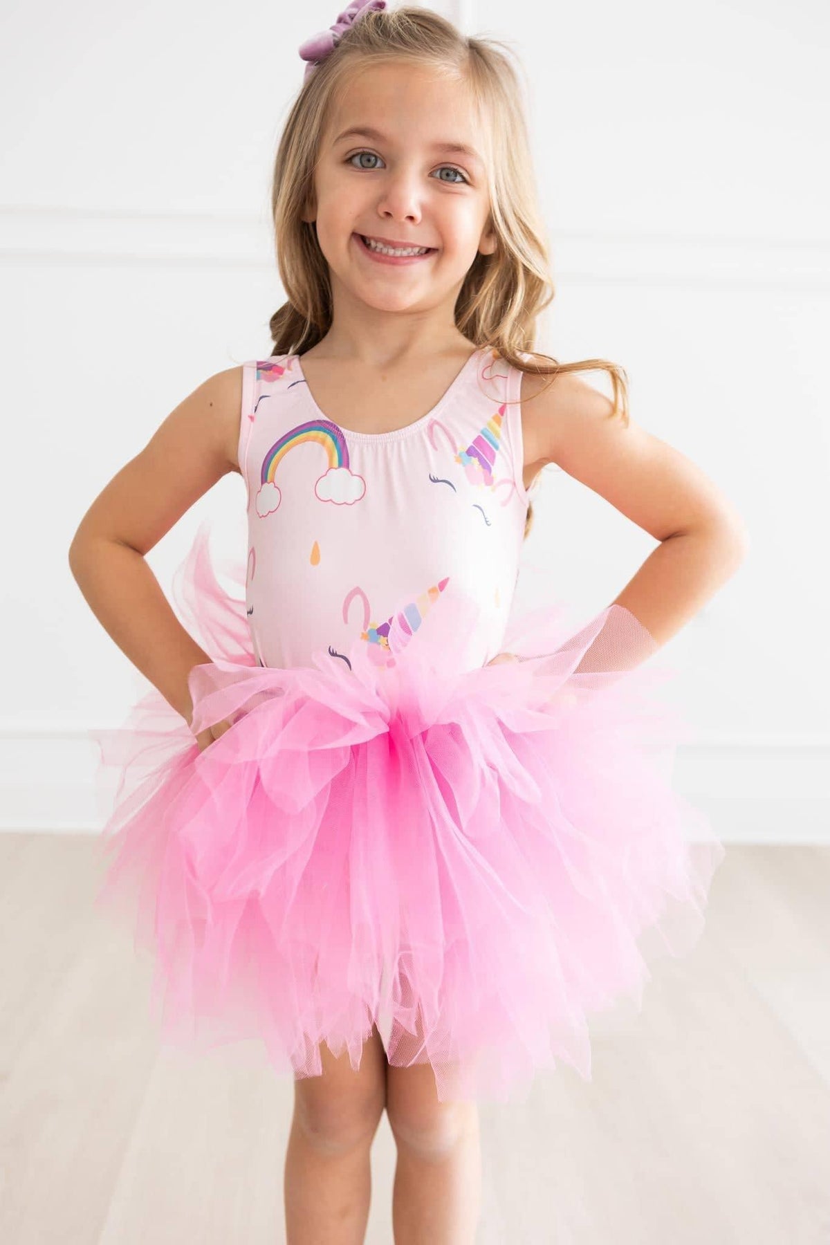 Girl wearing pink unicorn tutu leotard for girls standing with hands on hips smiling