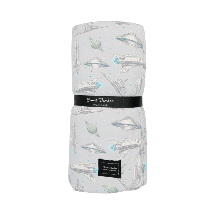 Rolled-up blanket with space-themed design on a green background