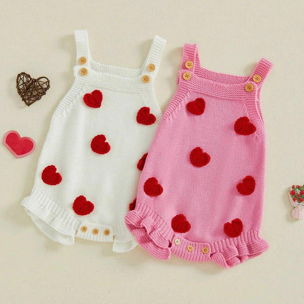 Pink and white knitted Valentine's Day baby romper with red heart accents and wooden buttons