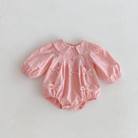 Pink baby girl bubble romper with long sleeves and decorative bows for infants