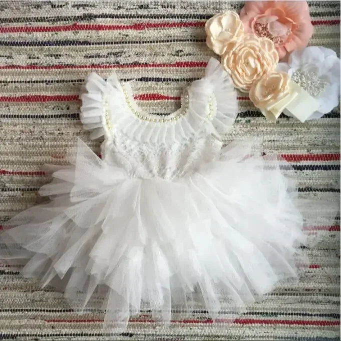 White vintage baby girl dress with ruffled tulle skirt and pearl detailing on bodice for infants