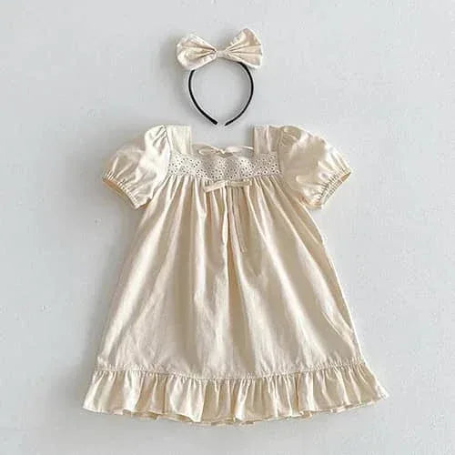 Cream vintage baby girl outfit made of soft cotton with puff sleeves and lace detailing