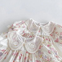 White cotton vintage baby girl outfit with pink floral print and lace eyelet collar