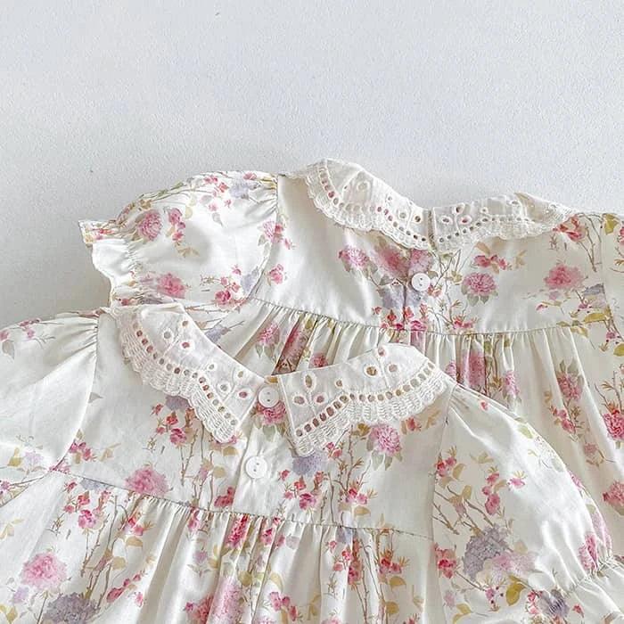 White cotton vintage baby girl outfit with pink floral print and lace collar detail