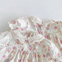 White cotton vintage baby girl outfit with pink floral print and lace collar detail
