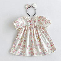 White cotton vintage baby girl outfit with pink floral print and matching fabric bow headband