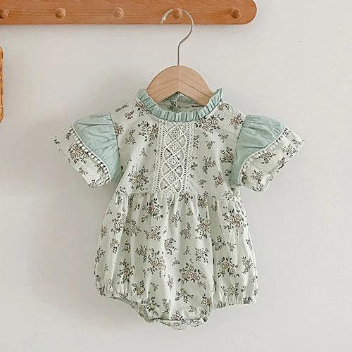 mint green vintage floral baby romper with lace detail for infant hanging on wooden hanger