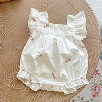 white vintage floral baby romper with pink flowers and lace sleeves laid flat for newborns