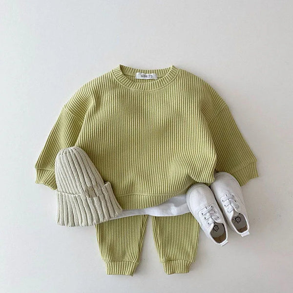 toddler green waffle cotton baby knit set with long sleeve top and pants, paired with beige knit hat and white shoes