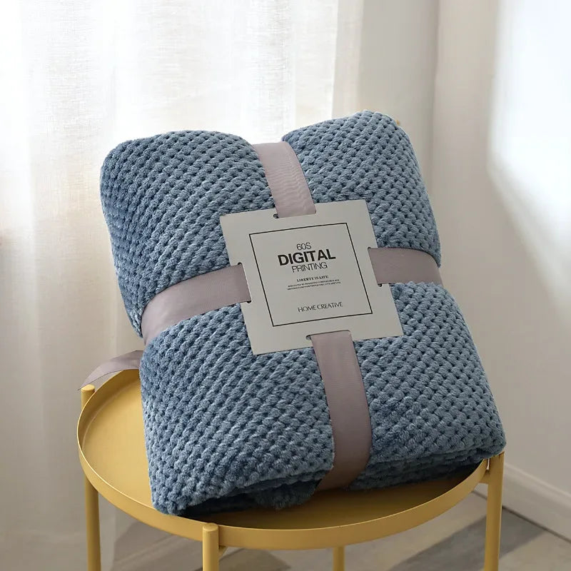 Blue waffle cut baby blanket swaddle folded and tied with a ribbon, ideal for newborns and infants