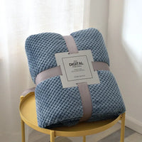 Blue waffle cut baby blanket swaddle folded and tied with a ribbon, ideal for newborns and infants