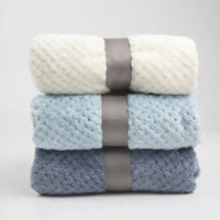 Set of three waffle cut baby blankets in white, light blue, and gray for newborn swaddling